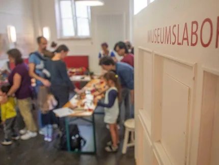 Der Blick ins Museumslabor zeigt eine Gruppe beim gestalten kreativer Drucke