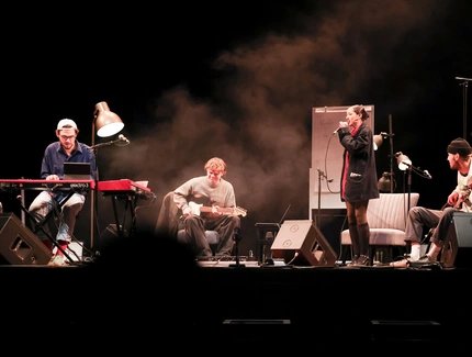 Eine vierköpfige Band bestehend aus Keyboarder, Gitarrist, Bassist und Sängerin spielt auf einer Bühne.