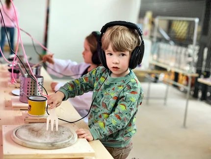 Zwei Kinder mit Kopfhörern im Musikbereich des Knidermuseums