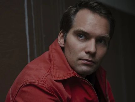 Portrait von Simon Strauß: seitliche Schulteraufnahme eines Mannes in roter Jacke