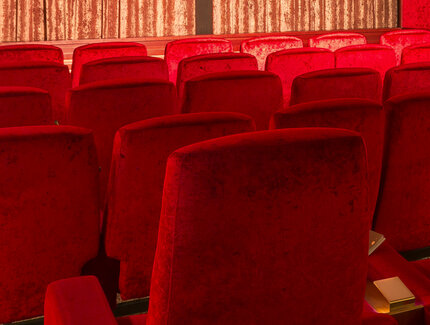 Rote Sitzreihen in einem Kinosaal