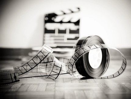 Nahaufnahme einer Filmrolle auf einer Holzplatte an einer Wand
