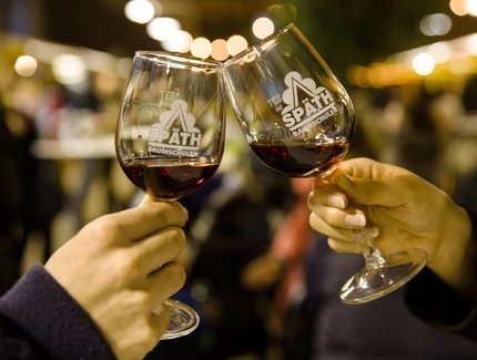 Weingläser mit Späth-Logo und Rotwein beim Anstoßen