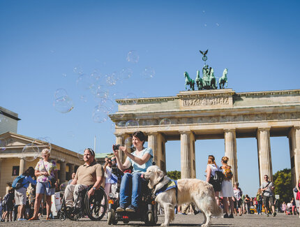 Barrierefrei: Frau im Rollstuhl vor dem Brandenburger Tor