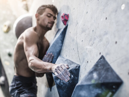 Homme athlétique sur un mur de bloc