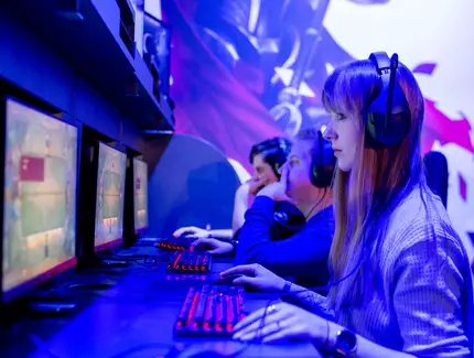 EGX Berlin: People with headphones on desktop computers