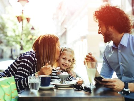 Vater und Mutter sind mit ihrem Kind im Café