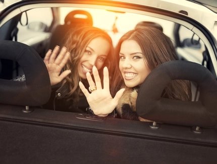 Winkende Frauen vom Rücksitz