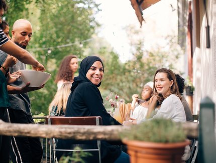 Portrait of young woman sitting with friends in balcony during party