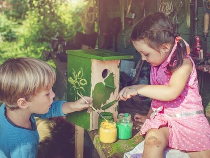 Kinder bemalen Vogelhäuschen