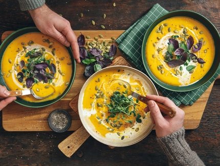 Männer, die vegane Kürbiscremesuppe essen