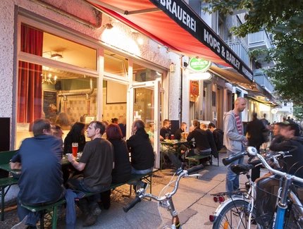 People sitting outside of the micro brewery Hops & Barley in Berlin-Friedrichshain