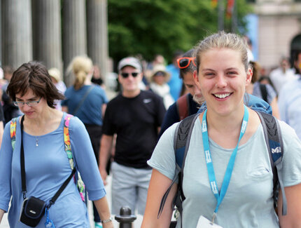 People and tourists walk through Berlin with a guided city tour