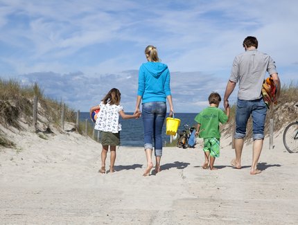 family walking towards the beach