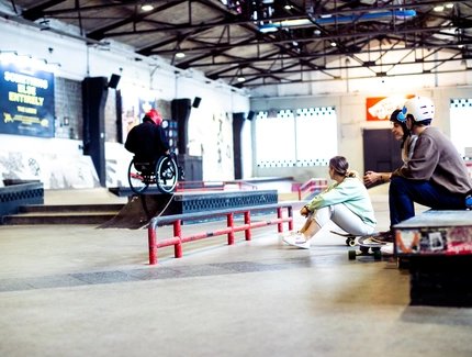 Skatehalle Berlin: Dos patinadores observan el patinaje en silla de ruedas