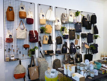 Second hand and vintage shop with bags on a grid on the wall 