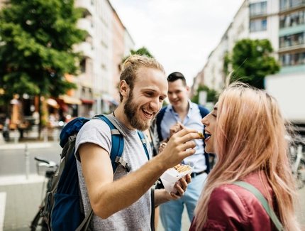 Young Couple Enjoy A Snack Together During A Bus Journey Rest Stop