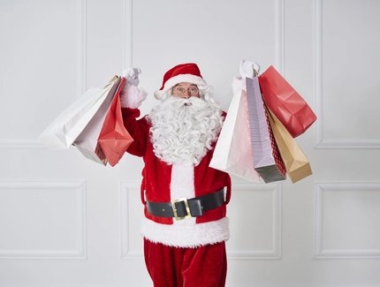 Portrait of Santa claus holding shopping bags