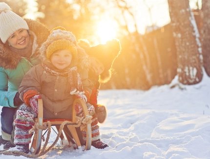 Mutter mit zwei Kindern auf einem Schlitten