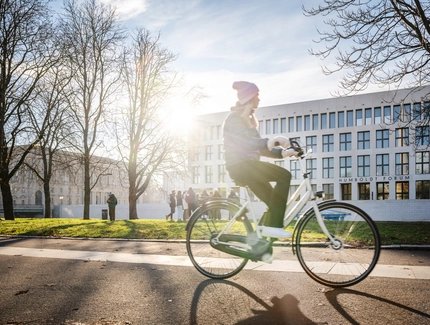 Radfahrerin vor dem Humboldtforum in Berlin im winterlichen Sonnenschein