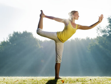 Frau praktiziert Yoga im Park