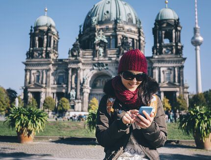 Touristin mit Smartphone vor Berliner Dom 