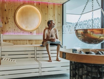 Man looking through window while sitting at finnish sauna