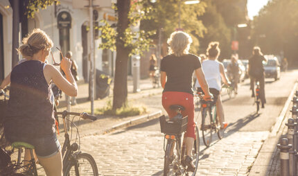 Eine Gruppe Fahrradfahren fahren durch Berlin im Sonnenschein