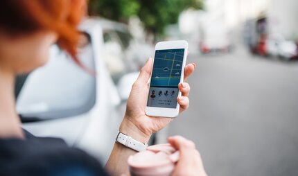 Carsharing: Frau in Berlin nutzt App auf ihrem Smartphone