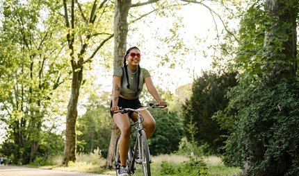 Junge Frau auf Fahrrad im Grünen