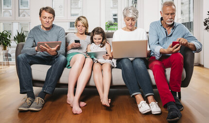 Familie mit verschiedenen digitalen Geräten