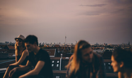 Freunde sitzen zusammen auf einem Dach
