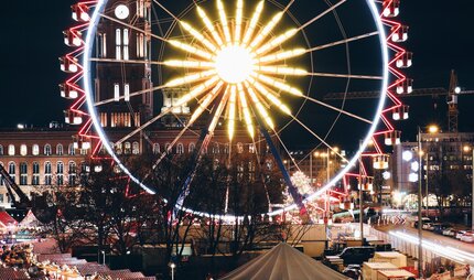 Der große Weihnachtsmarkt am roten Rathaus mit Riesenrad bei Nacht