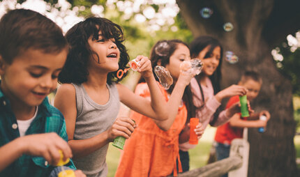 Kinder spielen mit Seifenblasen
