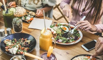 Healthy food in Berlin Hands view of young people eating brunch and drinking smoothies bowl with ecological straws in plastic free restaurant - Healthy lifestyle, food trends concept - Focus on top fork dish