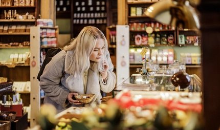 Eine junge Frau beim Weihnachtsshopping im Geschäft Winterfeldt Schokoladen in Berlin