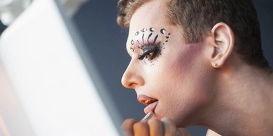 Drag Queen beim Schminken vor dem Spiegel