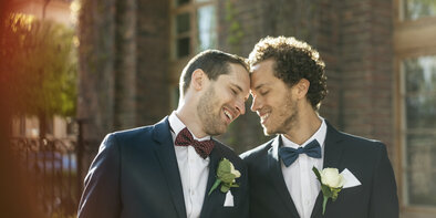 Happy newlywed gay couple standing outdoors