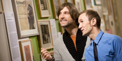 Two men look at pictures in the Gay Museum Berlin